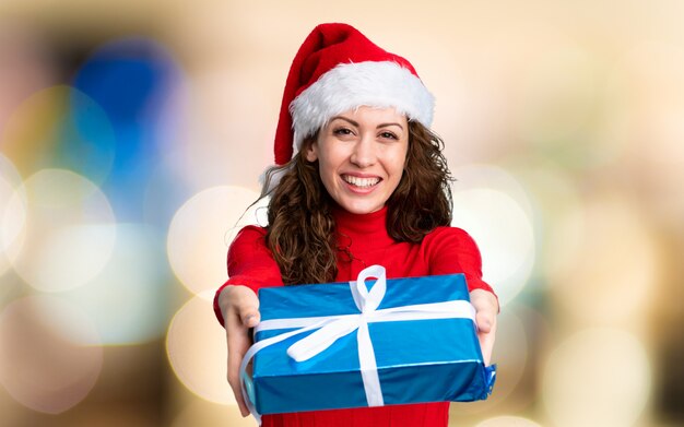 Fille avec un chapeau de Noël sur le mur