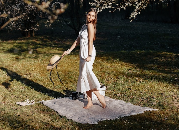 Fille avec un chapeau de paille au printemps dans le parc