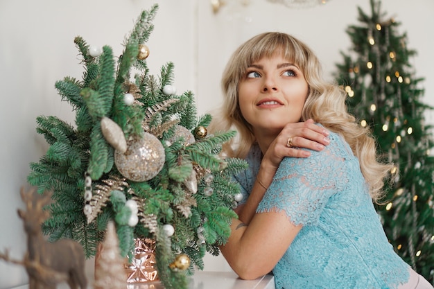 Fille charmante avec beau maquillage sur le visage en intérieur or et blanc. Vacances de Noël