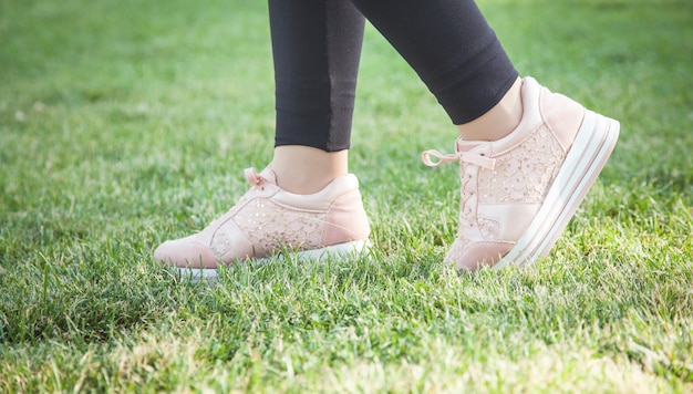 Fille de chaussures de course sur l'herbe dans le parc d'été.