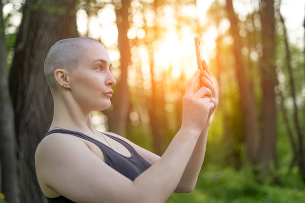 fille chauve avec téléphone portable dans ses mains