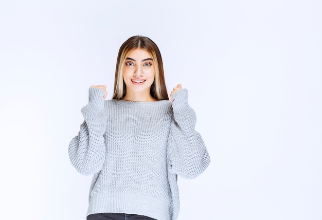 Fille en chemise grise semblant heureuse et motivée.