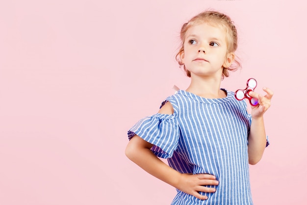 Fille en chemise rayée bleue joue spinner rouge à la main