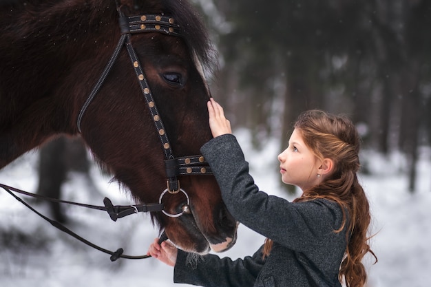 fille et cheval brun en hiver