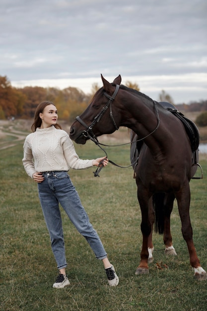 Une fille avec un cheval dans la nature, une promenade d'automne avec un animal