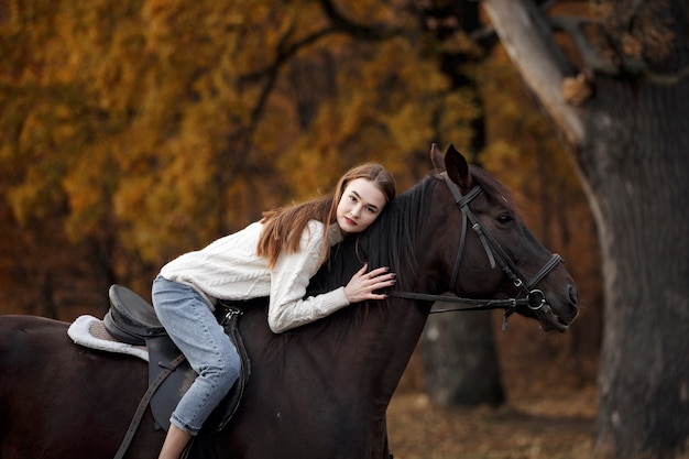 Une fille avec un cheval dans la nature, une promenade d'automne avec un animal