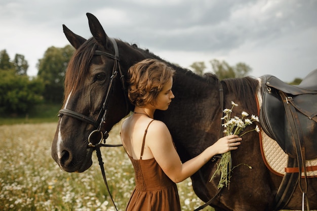 Une fille avec un cheval une robe marron un homme dans la nature avec un animal