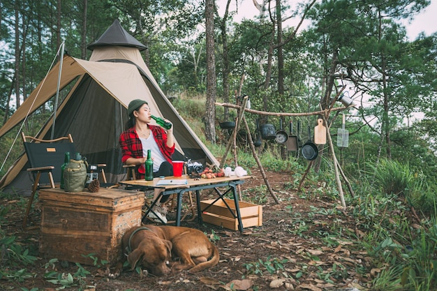 Fille et chien camping dans la forêt