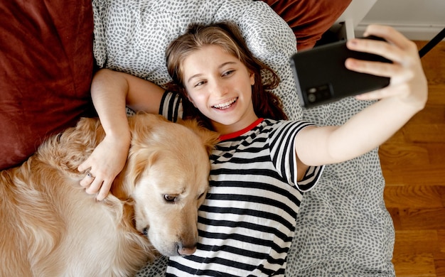 Photo fille avec chien golden retriever au lit