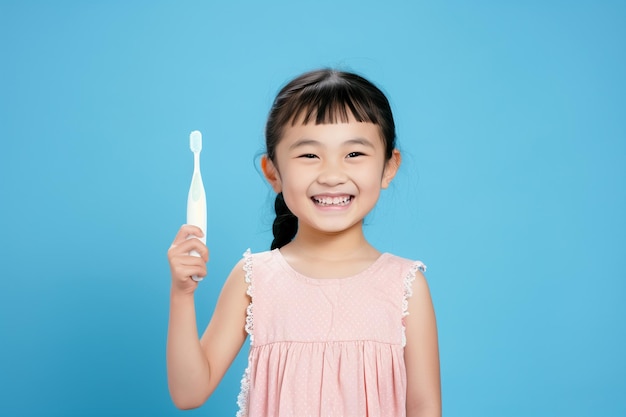 Une fille chinoise avec une brosse à dents à la main sur un fond bleu clair