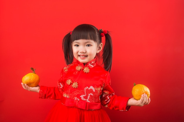 Une fille chinoise tenant des oranges pour la fête du printemps