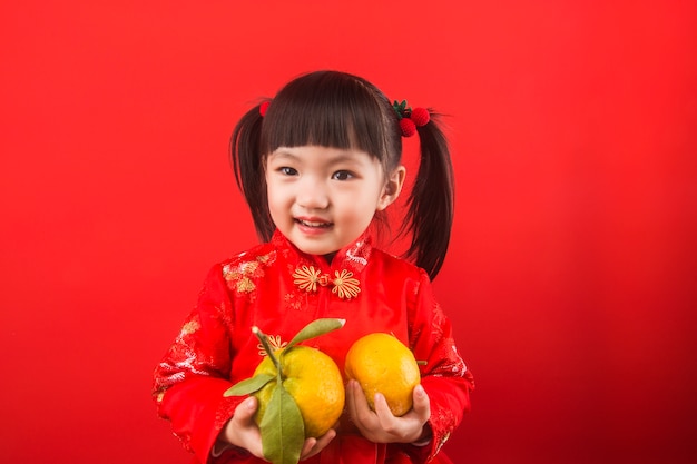 Une fille chinoise tenant des oranges pour la fête du printemps