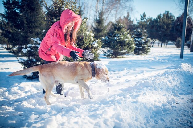 Fille avec un chiot Labrador chien jouant en plein air en hiver amusant