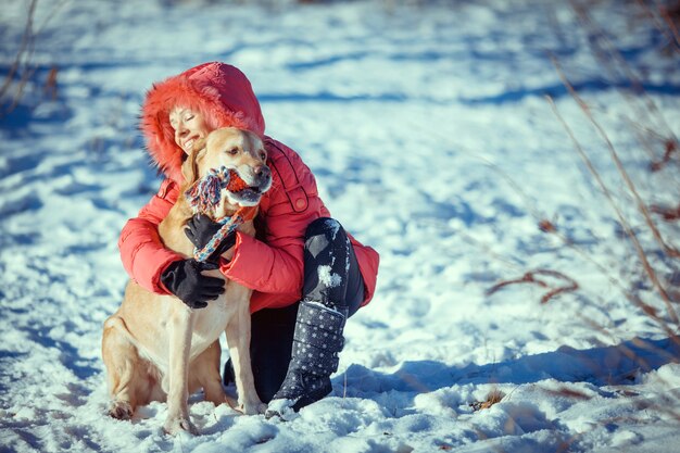 Fille avec un chiot Labrador chien jouant en plein air en hiver amusant