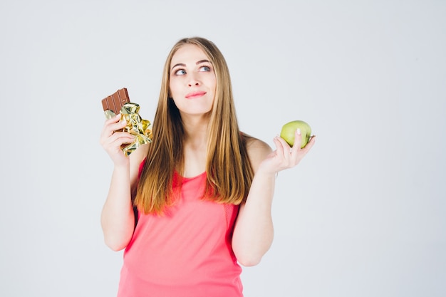 Fille choisit entre pomme et chocolat