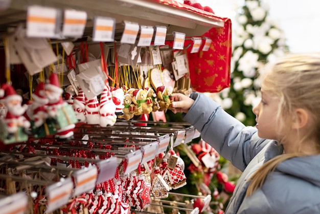 Une fille choisit les figurines pour le sapin de Noël