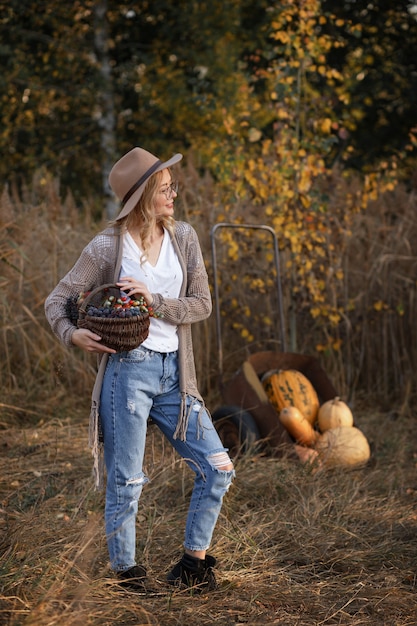 Fille avec des citrouilles d'automne. Récolte