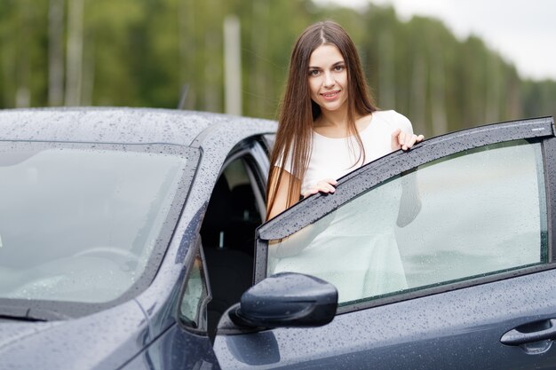 Fille avec clés et accord sur fond de concessionnaire automobile