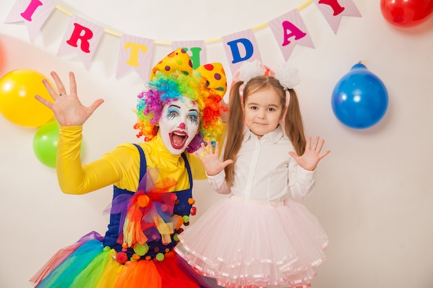 Fille de clown à la fête embrasse la fille d'anniversaire