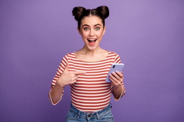 fille avec une coiffure à la mode à l'aide de téléphone isolé sur violet