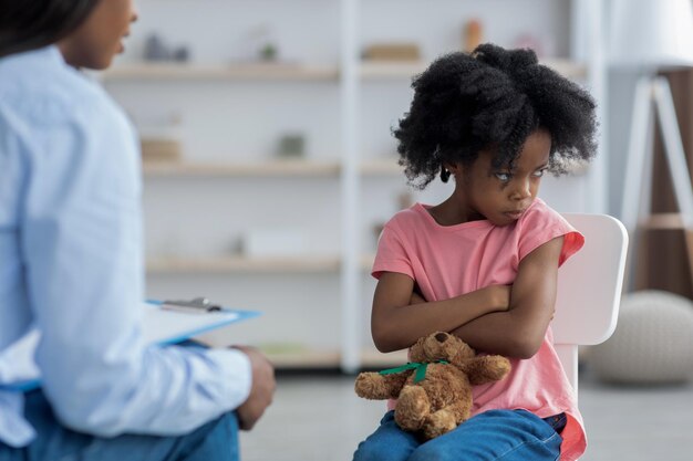 Fille en colère avec les bras croisés sur la poitrine parlant au psychologue