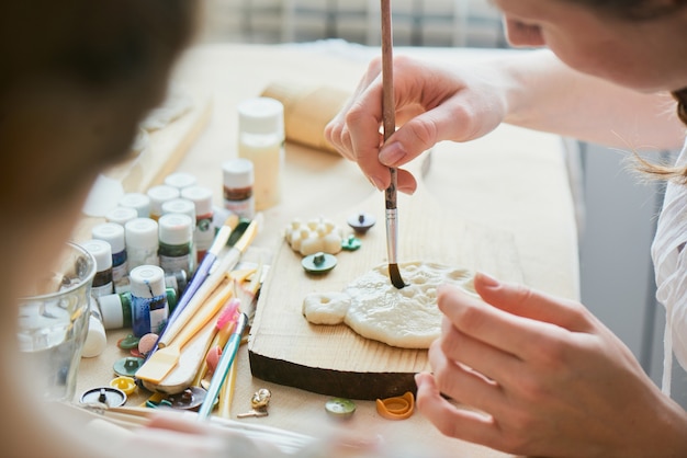 La fille colore la pâte à la main