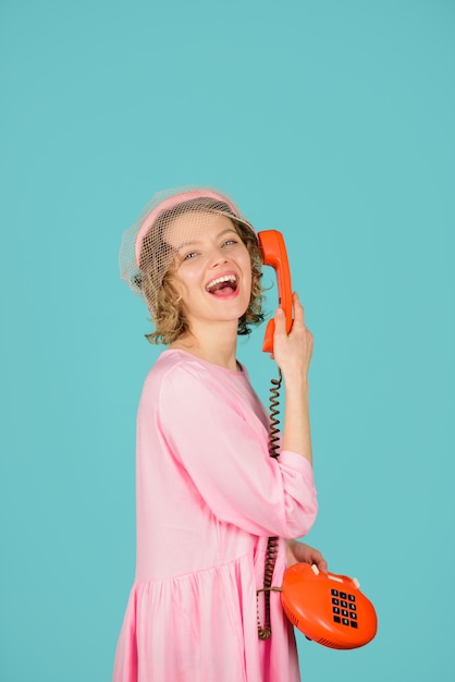 Fille de communication parlant au téléphone fixe fille souriante parlant au téléphone rétro femme heureuse en rose