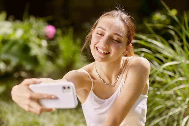 Fille communique en ligne au téléphone dans la nature chat en ligne dans la nature