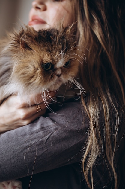 La fille communique avec son chat domestique moelleux rouge. L'amour pour les animaux.