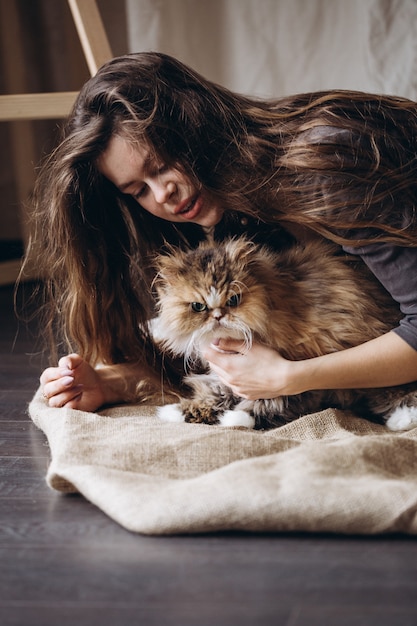 La fille communique avec son chat domestique moelleux rouge. L'amour pour les animaux.