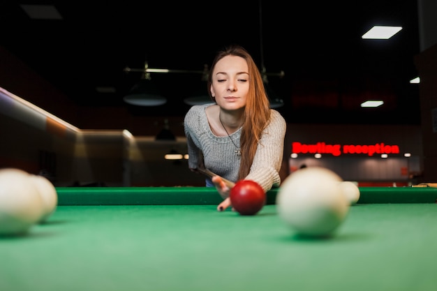 Fille concentrée tout en jouant au billard