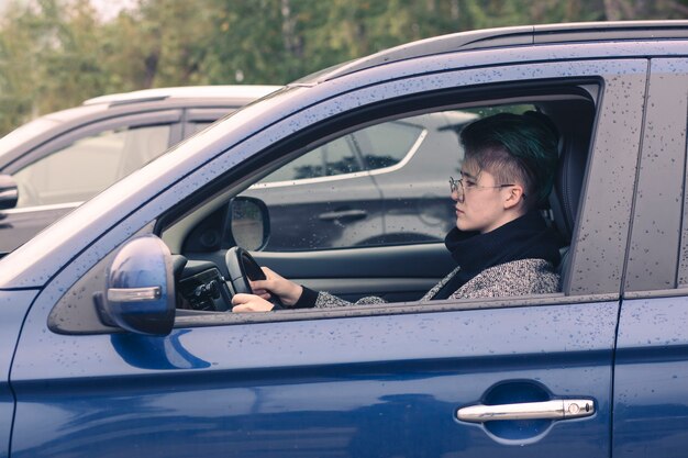 Fille conduisant une voiture. Formation à la conduite, achat, location de voiture.