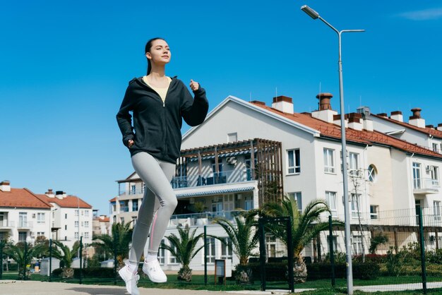 Une fille confiante active est engagée dans le jogging à l'extérieur veut perdre du poids