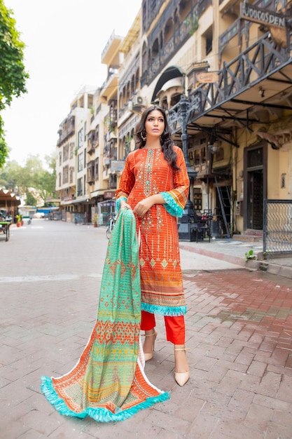 Fille confiante montrant sa robe Desi et ses bijoux pour une séance photo de mode à Food Street Lahore