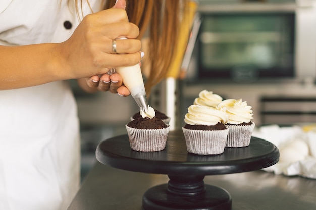 Une fille de confiseur prépare des ingrédients de concept de cupcakes pour la cuisson de produits à base de farine ou de desserts