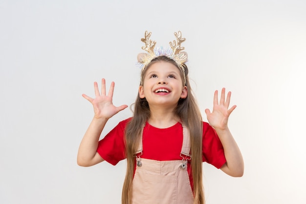 Une fille en costume du Nouvel An lève les yeux et met ses mains sur le côté.