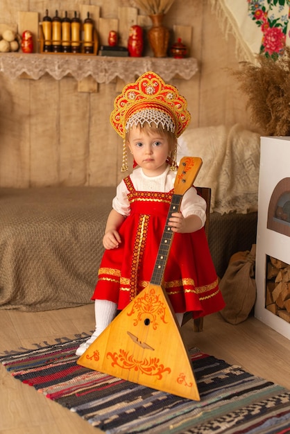 Une fille en costume national rouge avec une balalaïka Pancake day