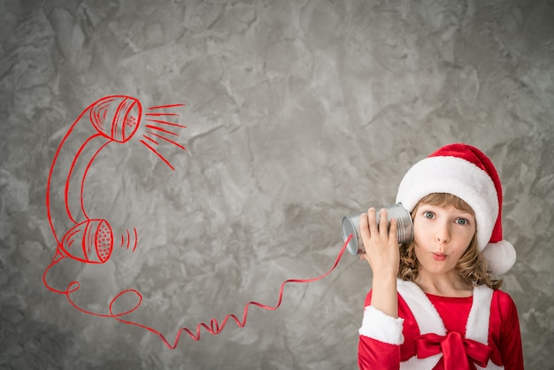 Fille en costume de père Noël avec téléphone bricolage