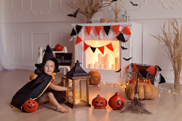 Photo fille en costume de sorcière halloween avec citrouilles