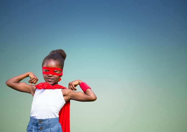 Fille en costume de super-héros fléchissant ses bras sur fond vert