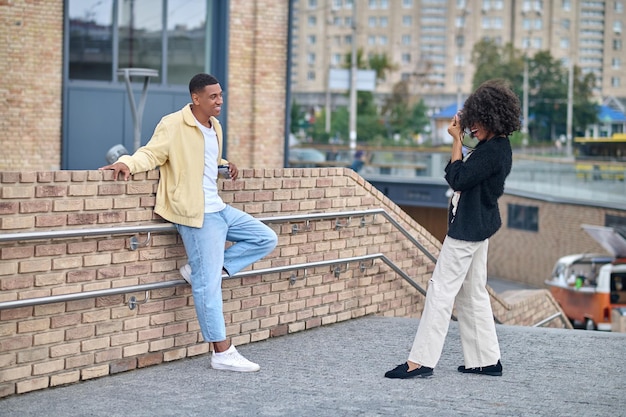 Fille sur le côté à l'appareil photo photographiant un gars posant