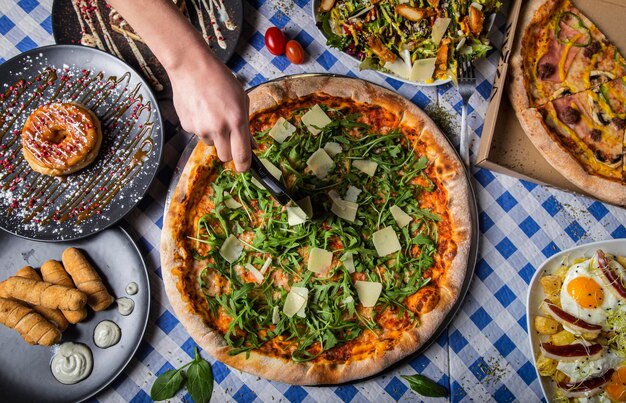 Fille couper la pizza sur la table se bouchent