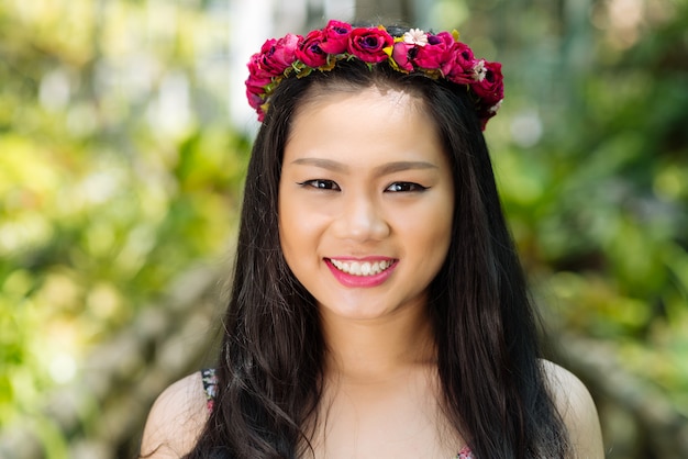 Fille avec une couronne de roses rouges