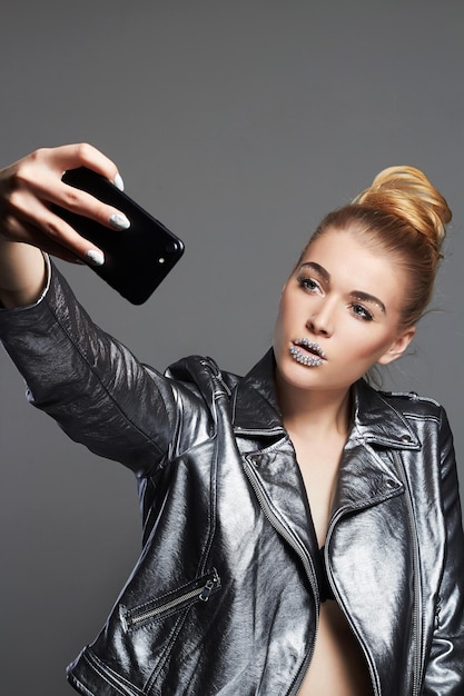 Fille avec des cristaux sur les lèvres faisant selfie