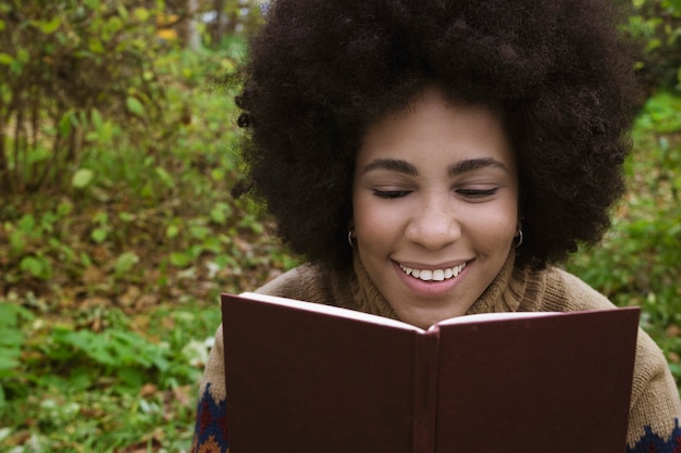 Photo une fille cubaine appréciant la lecture dans le parc avec son chien