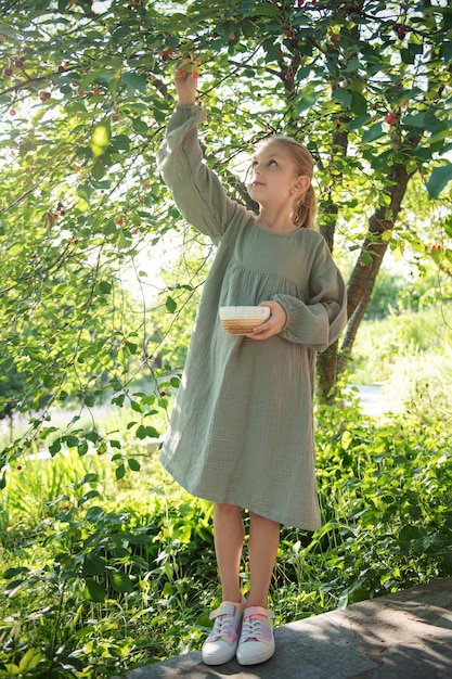 Fille cueillant des cerises