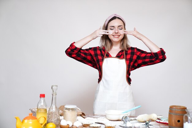 Fille de cuisine, fille en tablier, fille drôle tachée de farine