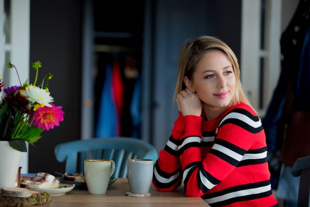 fille à la cuisine avec une tasse à l&#39;heure du petit déjeuner.