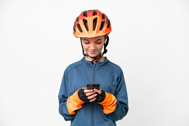 Fille cycliste adolescente sur fond blanc isolé envoyant un message avec le mobile