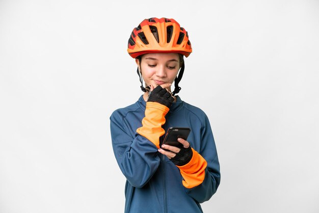 Fille cycliste adolescente sur fond blanc isolé pensant et envoyant un message